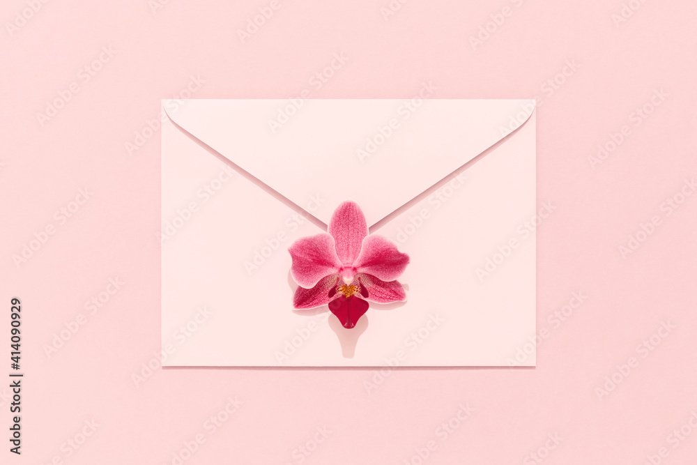 Orchid flower on pink envelope. Congratulation card, Womens Day, Mothers Day, Valentines, birthday.