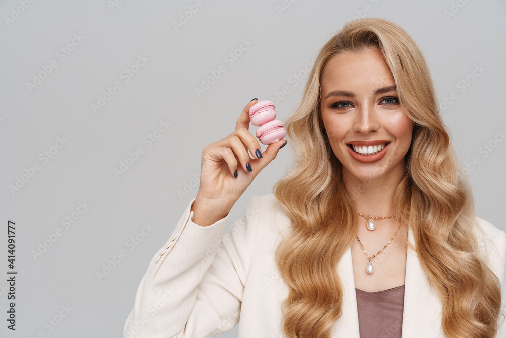 Beautiful happy girl in jacket smiling while posing with macaroons Beautiful happy girl in jacket smiling while posing with macaroons