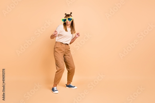 Full size photo of young attractive girl pouted lips wear sunglass dance isolated over beige color background © deagreez