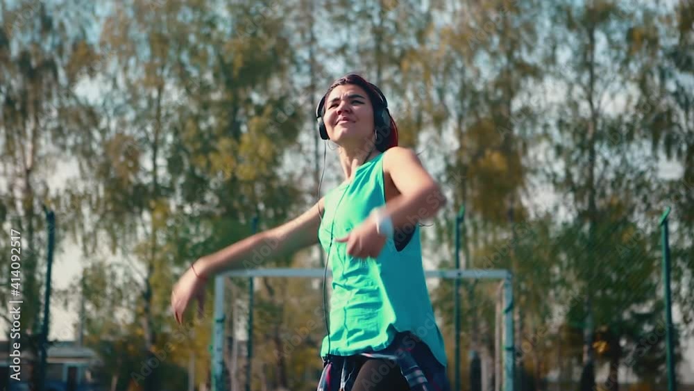 Girl Wearing Headphones Dancing Outdoor Sports Ground Hip Hop Break Dance Teaching Concept Youth subculture. Contemporary choreography. Girl Wearing Headphones Dancing Outdoor Sports Ground Hip Hop Break Dance Teaching Concept Youth subculture. Contemporary choreography.