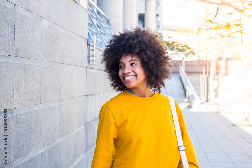 one young and beautiful businesswoman walking after working day in the office. Cheerful African or American girl one young and beautiful businesswoman walking after working day in the office. Cheerful African or American girl