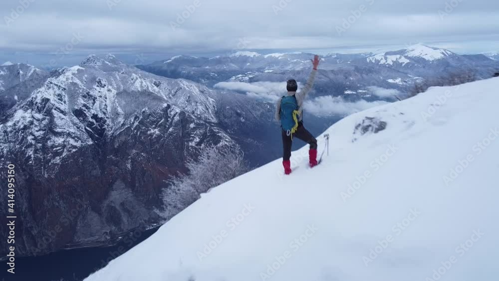 Hiker with backpack standing on mountain waving at Lake Como, Italy Hiker with backpack standing on mountain waving at Lake Como, Italy