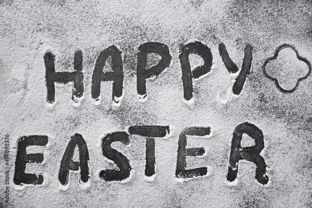 Words Happy Easter written in flour on black table, top view. Baking cake Words Happy Easter written in flour on black table, top view. Baking cake