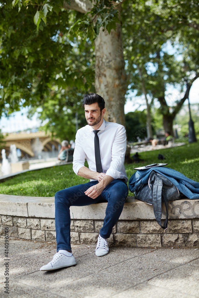 Young businessman resting at park. Young businessman resting at park.