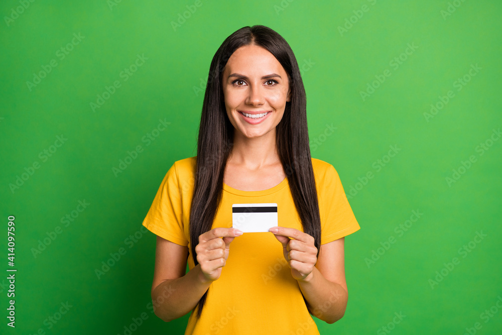 Photo of lovely happy young girl hold debit card salary spend good mood isolated on green color background Photo of lovely happy young girl hold debit card salary spend good mood isolated on green color background