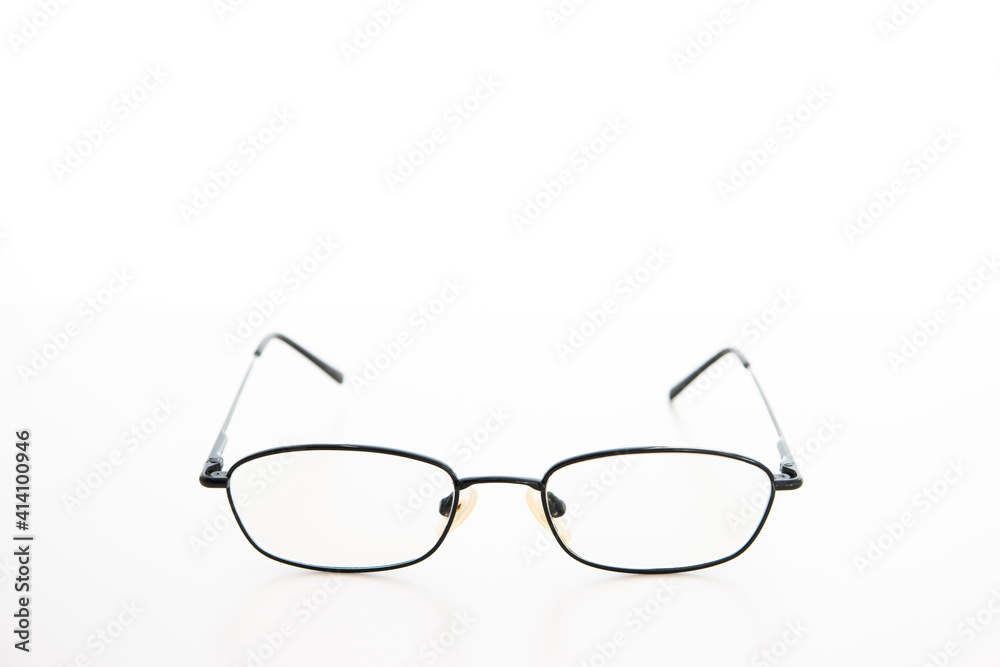 Fototapeta premium Simple used black metal wire glasses frame and lens close up studio shot isolated on white