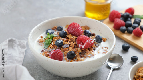 Granola bowl with fresh blueberries, raspberries and almond milk. Healthy breakfast food or snack