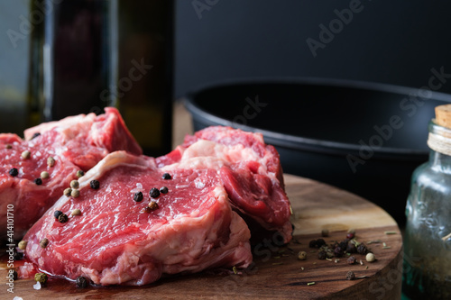 Raw meat on wooden board with dark background