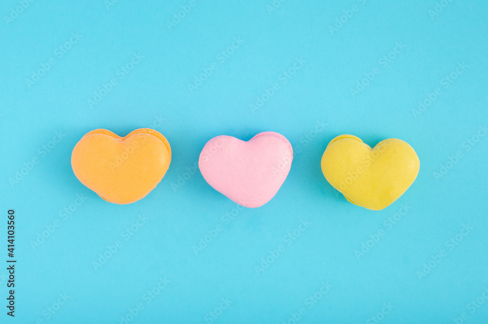 Creative Valentines day concept with three heart shaped macaroons on pastel blue background. Flat lay design