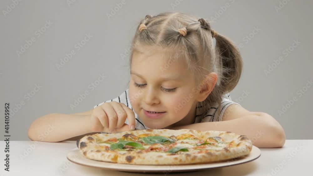 Cute preschool girl eats delicious pizza and enjoys Italian cuisine. Cute preschool girl eats delicious pizza and enjoys Italian cuisine.