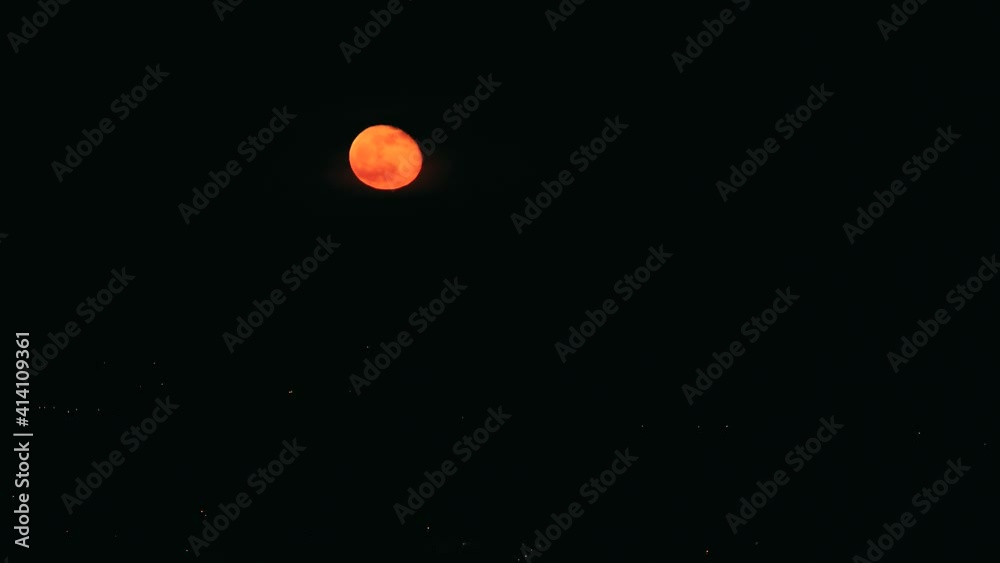 Time-lapse shooting, red lush round moon moving in the black night sky. Full moon Time-lapse shooting, red lush round moon moving in the black night sky. Full moon