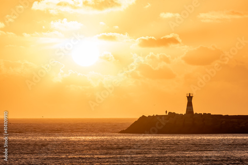 Sunset on the beach with tower in the background, yellow tone