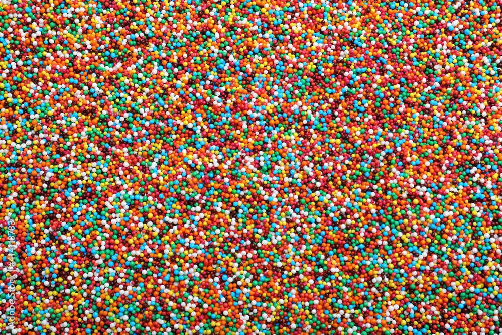 Bright colorful sprinkles as background, top view. Confectionery decor