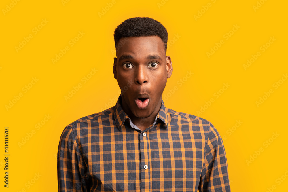 Portrait Of Surprised African American Guy Opened Mouth In Amazement, Yellow Background Portrait Of Surprised African American Guy Opened Mouth In Amazement, Yellow Background