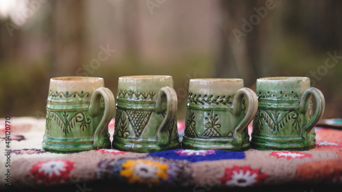 Old mugs on a crocheted blanket. Hand made clay mugs. How to make clay mugs.