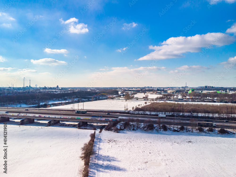 View of the snow-covered skyline of Duisburg on a sunny winter day from above