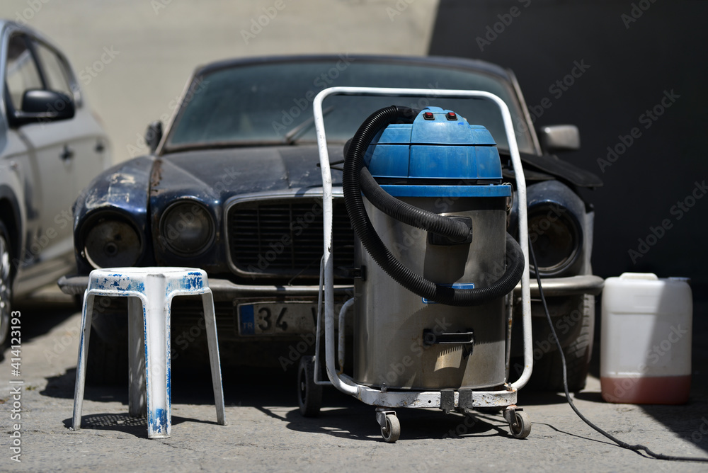 Obraz premium industrial retro vacuum cleaner on background old dirty car