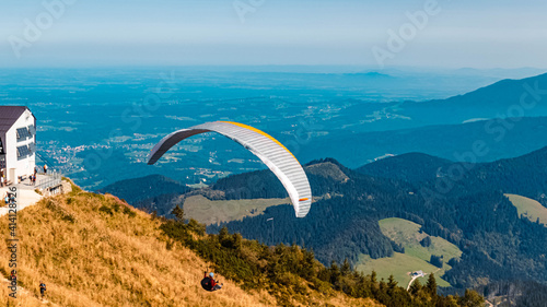 Beautiful alpine summer view with a paraglider at the famous Hochfelln summit, Bergen, Bavaria, Germany