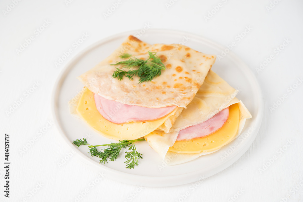 Homemade pancakes with ham and cheese on a white background, Maslenitsa, top view Homemade pancakes with ham and cheese on a white background, Maslenitsa, top view