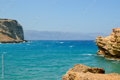Rocks, turquoise sea water, and blue Cycladic sky