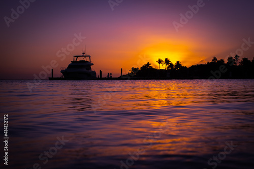 A boat silhouetted against the setting sun