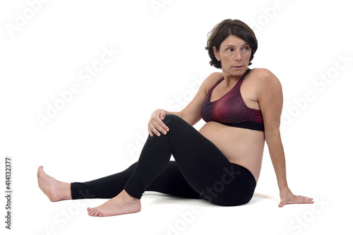 pregnant woman doing floor exercises on white backgroun, vakrasana photo