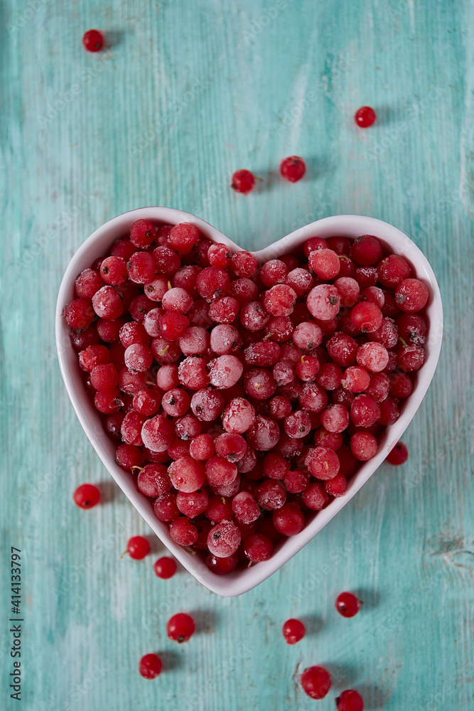 frozen red currants on wooden surface frozen red currants on wooden surface