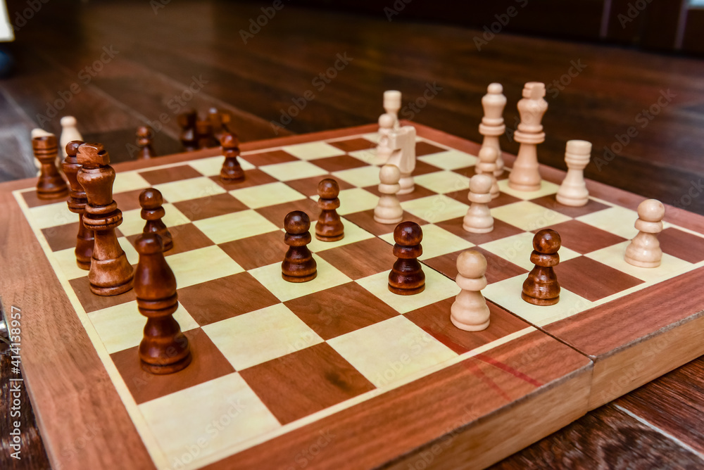 White and black chess pieces stand on board during a chess game White and black chess pieces stand on board during a chess game