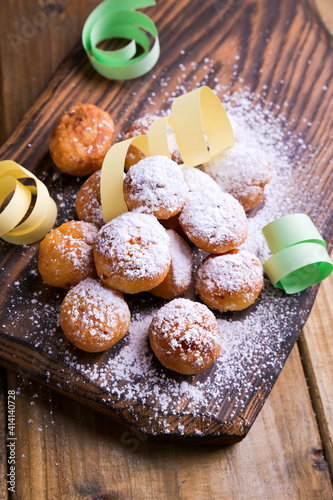 Baked castagnole with powdered sugar and confetti. Street food, round biscuits with sugar for the carnival of Venice. Traditional sweet pastries during the carnival period in italy. photo