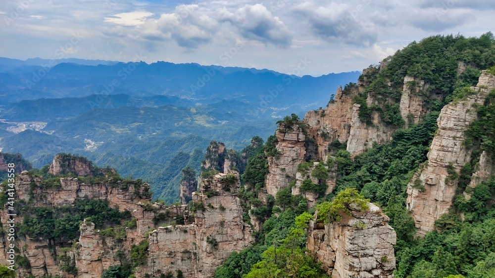 The sandstone pillars. Mountains in the national park Wulingyuan. Mountain valley. Trees on rocks. Zhangjiajie. UNESCO World Heritage Site. China. Asia The sandstone pillars. Mountains in the national park Wulingyuan. Mountain valley. Trees on rocks. Zhangjiajie. UNESCO World Heritage Site. China. Asia