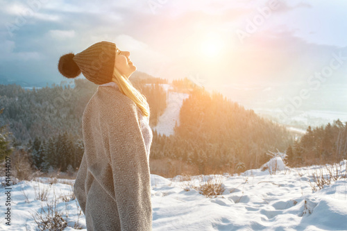 Happy woman traveler on the top of mountain and looking on beautiful winter snowy view. 