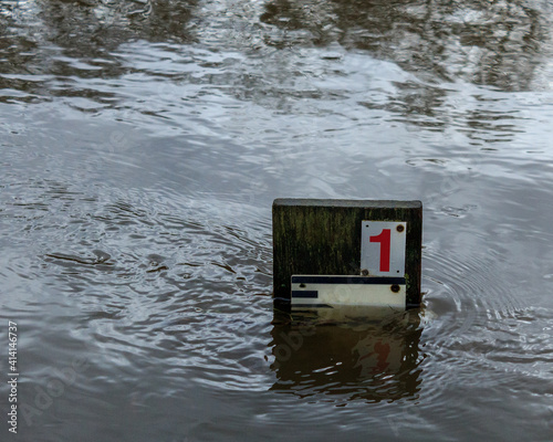 фотографія The river swirls around the gauge indicating that the rising level could soon ca