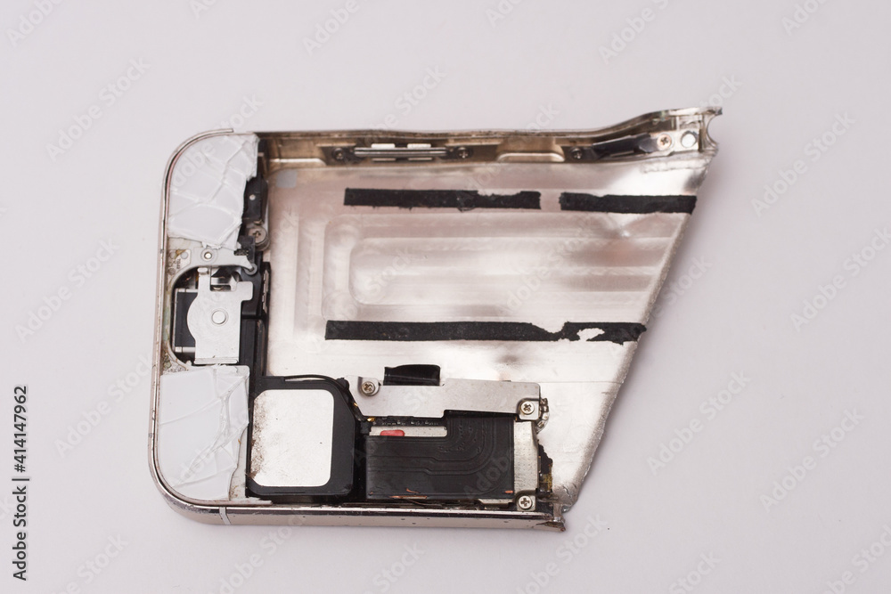 Broken electronic device, a piece of metal siver smartphone on white background
Broken electronic device, a piece of metal siver smartphone on white background