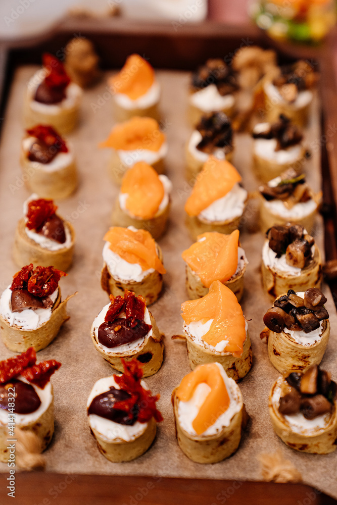 Catering. pancake rolls with curd cheese, fish, jerky tomatoes and mushrooms. portioned serving of dishes. service to dinner parties, banquets and holidays. Restaurant.