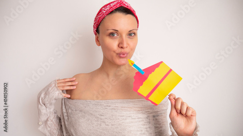 Portrait of a woman blowing out a candle on a fake cardboard cake. 