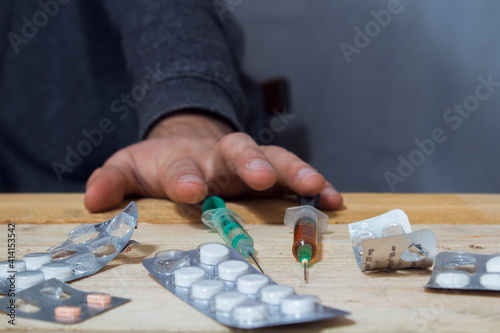 addict next to pills and syringes