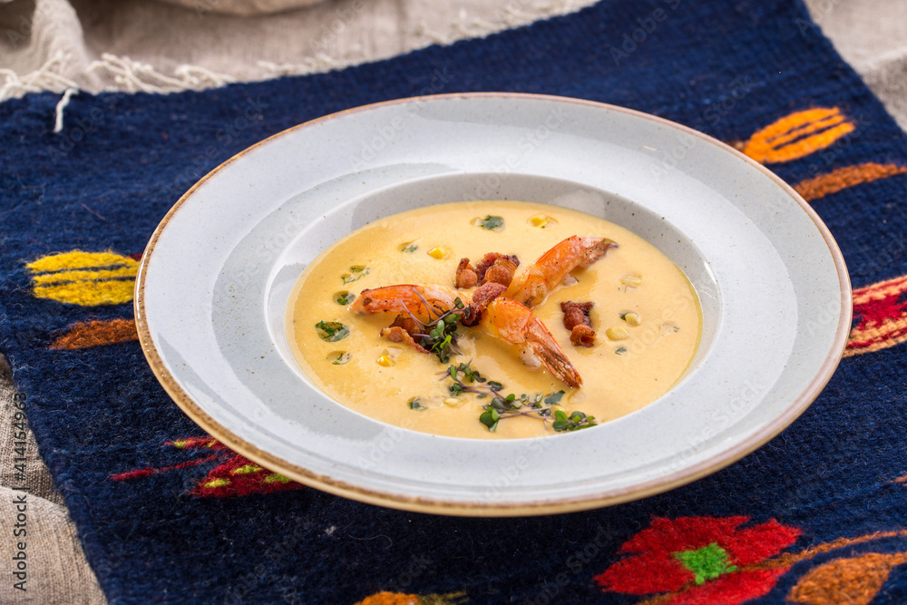 Corn cream soup with shrimp and bacon on the table Corn cream soup with shrimp and bacon on the table