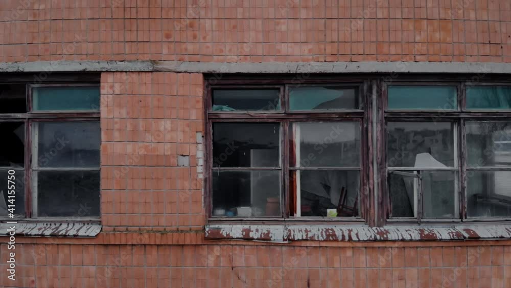 The facade of an old house with broken window frames and glass. Aerial view. The facade of an old house with broken window frames and glass. Aerial view.