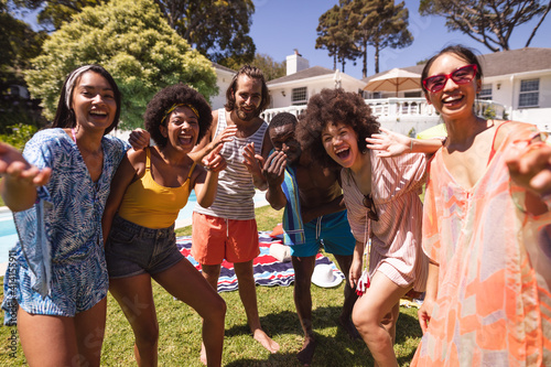 Fototapeta Diverse group of friends having fun and smiling at a pool party