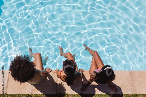 Photo Diverse group of female friends sitting at the poolside