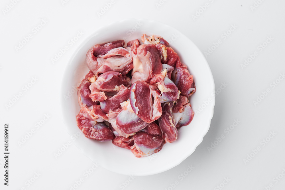 raw chicken thighs on a white plate on a white background. Photo for clipping raw chicken thighs on a white plate on a white background. Photo for clipping