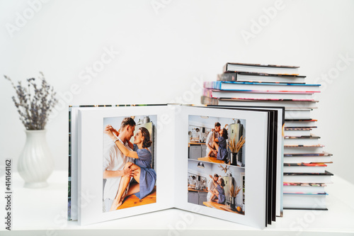 stack of books. open photobook from photo shoots of a beautiful happy couple