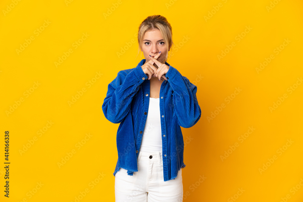 Young Russian woman isolated on yellow background showing a sign of silence gesture Young Russian woman isolated on yellow background showing a sign of silence gesture