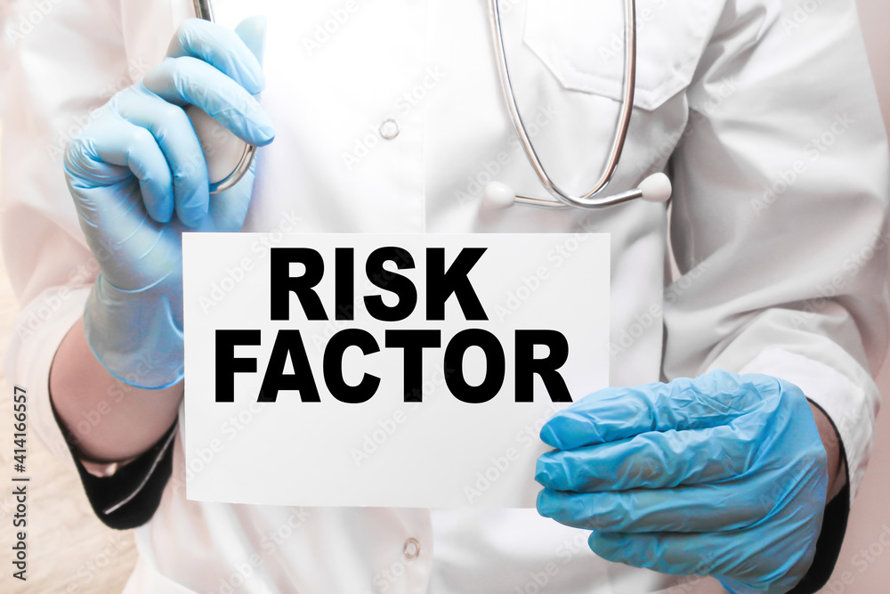 The doctor's blue - gloved hands show the word RISK FACTOR - . a gloved hand on a white background. Medical concept. the medicine The doctor's blue - gloved hands show the word RISK FACTOR - . a gloved hand on a white background. Medical concept. the medicine