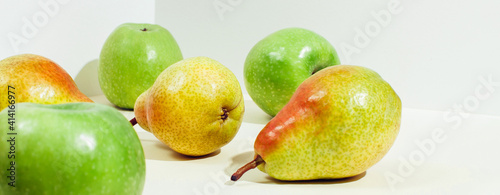 Icometric view of pears and apples in sunlight. Horizontal banner