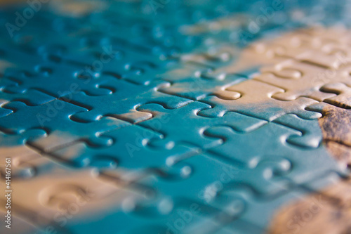 Jigsaw puzzle. Closeup of blue jigsaw puzzle peices. Conceptual photo with focus on completed puzzle