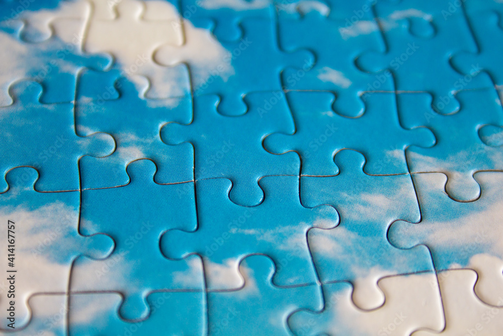 Jigsaw puzzle. Closeup of blue jigsaw puzzle peices. Conceptual photo with focus on completed puzzle Jigsaw puzzle. Closeup of blue jigsaw puzzle peices. Conceptual photo with focus on completed puzzle