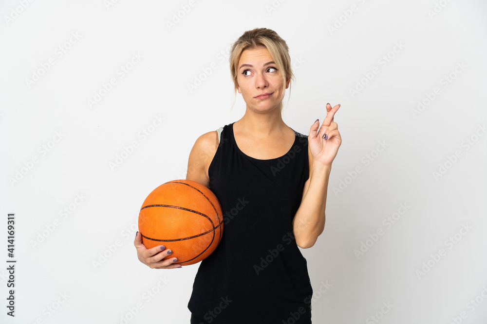 Young Russian woman playing basketball isolated on white background with fingers crossing and wishing the best Young Russian woman playing basketball isolated on white background with fingers crossing and wishing the best