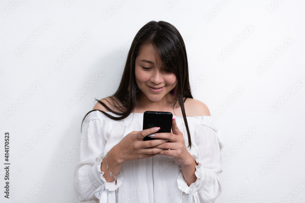 beautiful black Hispanic woman with long black hair using a cell phone on a white background beautiful black Hispanic woman with long black hair using a cell phone on a white background