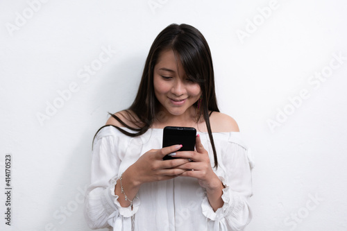 beautiful black Hispanic woman with long black hair using a cell phone on a white background